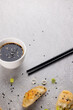 Overhead view of asian dumplings, soy sauce and chopsticks on grey background