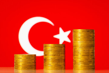 Upcoming graph made of golden coins on the background of flag of Turkey. Concept of development, growth, economic progress of Turkey