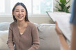 © Pormezz - Happy young Asian woman talking with the psychologist during depressed mental health therapy at the clinic.