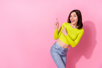 Photo of impressed funny girl dressed lime shirt pointing two fingers empty space isolated pink color background