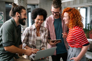 Diverse group of professionals meeting in office. IT programmers use computer, talk strategy