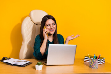 Wall Mural - Photo of young cheerful woman listen say speak communication mobile manager isolated over yellow color background