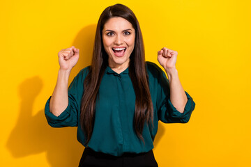 Canvas Print - Photo of charming lucky woman wear green shirt rising fists smiling isolated yellow color background