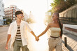 © ADDICTIVE STOCK - Diverse couple walking on pavement at sunset