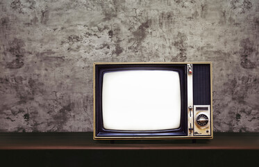 Wall Mural - Vintage old TV on wooden table with concrete wall background with copy space on the left.