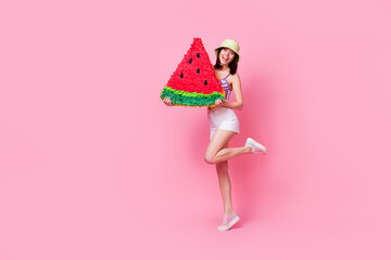 Poster - Full length photo portrait of shiny young woman holding big watermelon pinata dressed trendy singlet cap isolated on pink color background