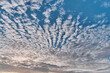 Amazing altocumulus clouds in form of ridges on blue sky.