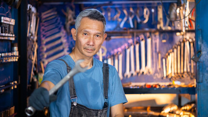 Wall Mural - Portrait senior asian male mechanic engineering working on Vehicle in a Car Service. Repair specialist, technical maintenance. Small business owner.