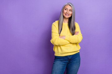 Photo of charming dreamy retired woman wear sweater arms crossed looking empty space isolated violet color background