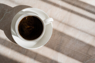 Poster - top view of cup of black coffee and white saucer on marble surface.