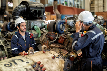 In heavy industry 2 maintenance  engineer work at site checking to overhaul mega 1000 horse power machine with electric generator supercharger turbo
