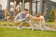 © zinkevych - Pleased man and his adorable dog in the backyard