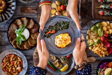 Wall Mural - Meatball with potatoes puree and cheese at the hands of two women. Hasanpasa Kofte 