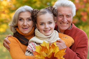 Wall Mural - Portrait of grandfather and grandmother of granddaughter in autumn