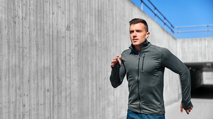 Wall Mural - fitness, sport, training and lifestyle concept - young man with wireless earphones running outdoors