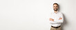 © Mix and Match Studio - Business. Young professional businessman in glasses smiling at camera, cross arm on chest with confidence, standing over white background