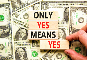 Wall Mural - Only yes means yes symbol. Concept words Only yes means yes on wooden blocks on a beautiful background from dollar bills. Businessman hand. Business, psychological only yes means yes concept.