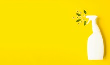 On A Bright Yellow Background, A White Spray Bottle With Detergent.  Creative Photography Of Chamomile Flowers And Mint Leaves Create A Spray Effect And Fragrant Freshness.  Flat Lay.  Banner.