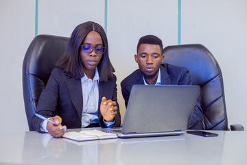 African businessman and woman in a conference room with a laptop