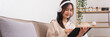 © Pichsakul - Concept of relaxation at home, Young Asian woman is wearing headphone and watching movie on tablet