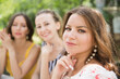 © ulza - three  young beautiful smiling woman have fun together in the summer garden and take selfies on a mobile phone.  female friends enjoying a holiday outdoors