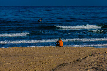 Poster - a man with a camera on the beach