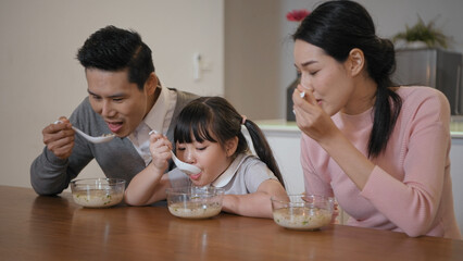 Family concept of 4k Resolution. Asian parents and children eating together in the house.