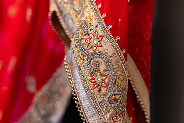 Indian Punjabi bride's red wedding outfit veil, textile, fabric and pattern close up