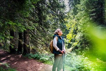 Active happy mature senior woman walking in beautiful autumn forest