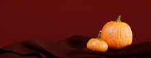 Seasonal Background Banner With Copy-space. Pumpkins With Dark Red Color Fabric. Autumn Concept.
