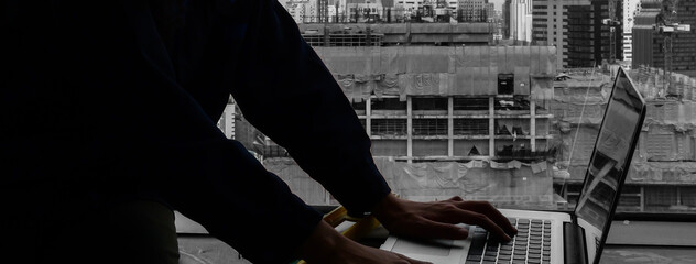 Hand of engineer using laptop, chart checking quality material production analyzing working in construction site.