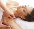 © Acronym - Hair removal, beauty and health concept. A young girl is getting an epilation procedure. A processional beauty worker is making depilation with hot wax.