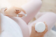 © Parilov - Closeup white round pill in hand of young pregnant woman, daily vitamins for hair, skin and health of baby