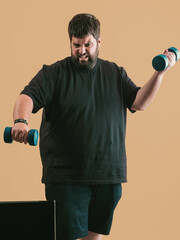 leafy young man exercises with weights on a neutral background