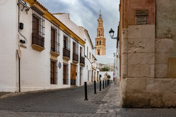 Wall Mural - Narrow alley between two buildings with a church in the middle in Ecija, Spain