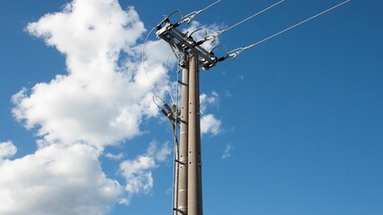 Sticker - Electric wire on a post with a cloudy blue sky background