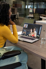 Poster - Vertical of happy biracial businesswoman making laptop video call with diverse colleagues on screen