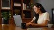© Prathankarnpap - Focused asian woman working online from home, typing email on her laptop computer