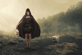 Fototapeta Miasto - Asian witch woman with a black cloak holding a lantern standing