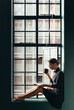 © Jacob Lund - Young woman reading book and drinking coffee