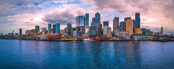 Wall Mural - Seattle city skyline at sunset, dramatic cloudscape, and the vista of the metropolitan downtown financial district over Elliot Bay in Washington State