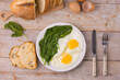 Breakfast on the table with fried eggs and spinach.