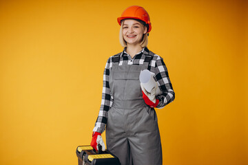 Woman builder holding tool box and wearing helmet