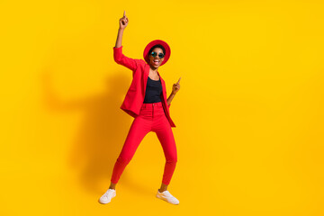 Wall Mural - Photo of excited cool short hair person dressed red suit cap spectacles dancing pointing empty space isolated yellow color background