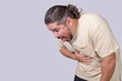 © Mdv Edwards - A nauseated man has a gag reflex. Having the urge to vomit. Scene isolated on a gray background.