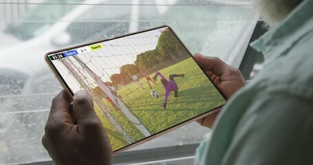 Wall Mural - Video of person sitting on the couch and watching football match on tablet