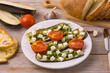 Grilled eggplant with feta cheese and grilled tomatoes on a white wooden background, closeup view.