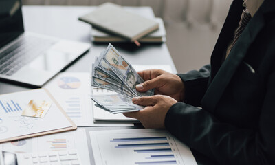 Businessman counting money for financial planning and accounting.