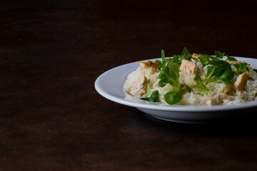 Wall Mural - Chicken and rice with Valeriana salad in a plate on a wooden table