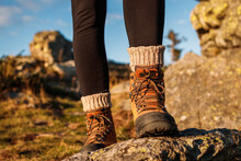 Hiking Boot With Knitted Socks. Female Legs On Mountain Peak During Trekking Outdoors